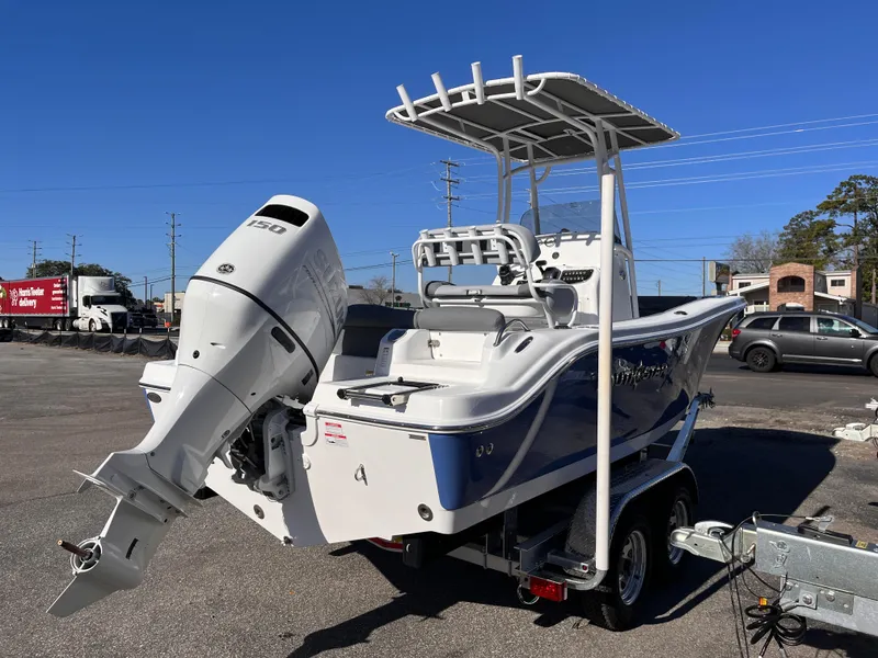 Slide: The Image of 2025 NauticStar 212 Legacy boat on trailer, featuring a powerful outboard motor. - 4