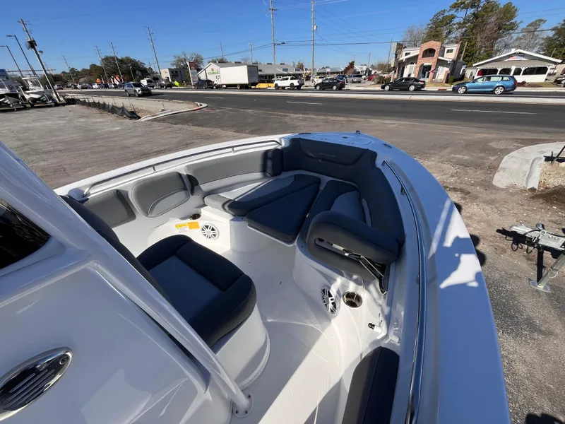 Slide: The Image of 2025 NauticStar 212 Legacy boat with spacious seating, parked near a busy street. - 9