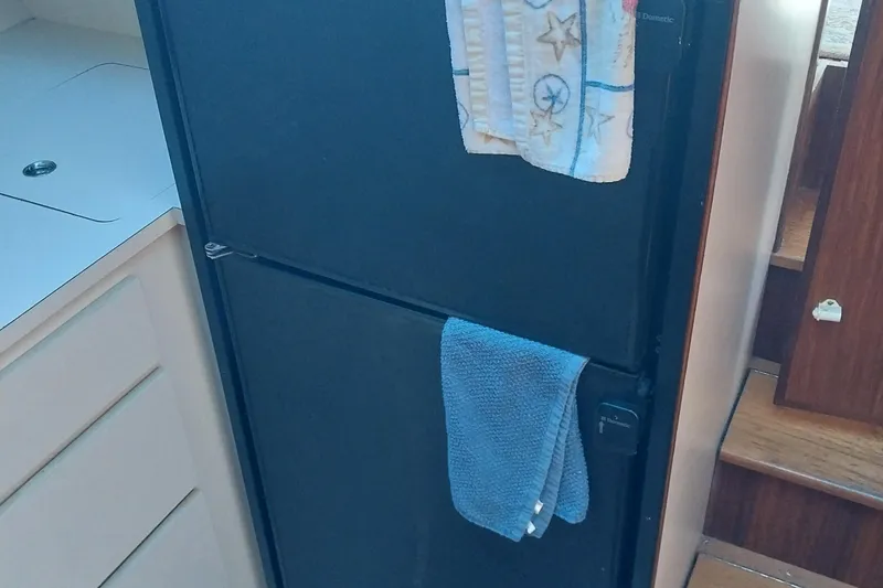 Slide: The Image of 1988 Hatteras 40 Double Cabin kitchen with black refrigerator and towels. - 17