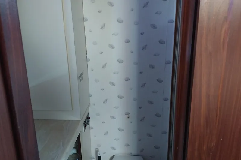 Slide: The Image of Bathroom interior of 1988 Hatteras 40 Double Cabin yacht with shell-patterned wallpaper. - 22