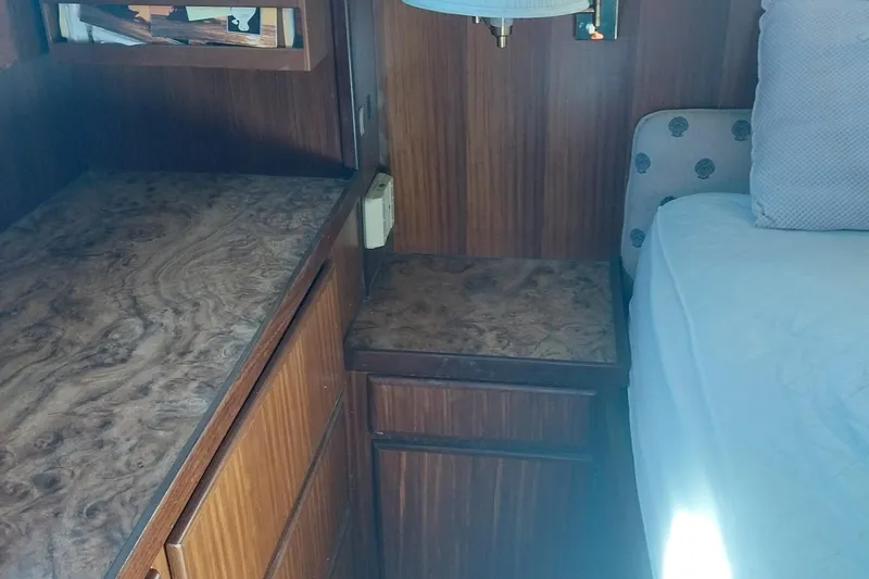 Slide: The Image of 1988 Hatteras 40 Double Cabin interior with wood cabinetry and bed. - 23