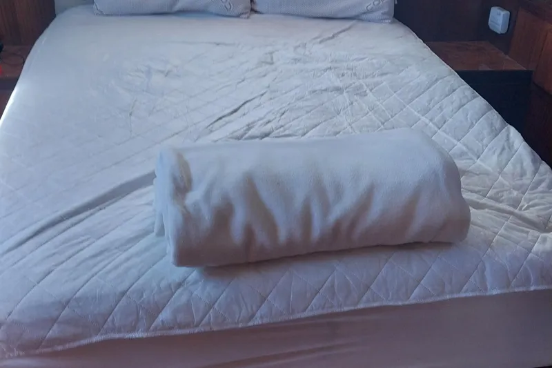 Slide: The Image of Bed with a rolled towel in a 1988 Hatteras 40 Double Cabin yacht. - 24