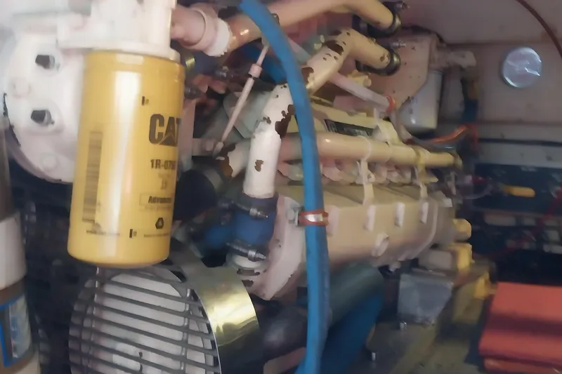 Slide: The Image of Engine room of 1988 Hatteras 40 Double Cabin with visible CAT filter and piping. - 27