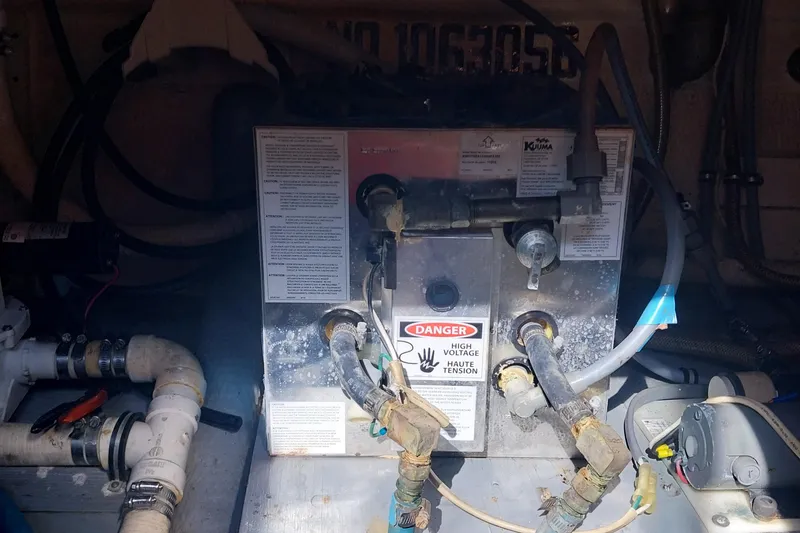 Slide: The Image of 1988 Hatteras 40 Double Cabin engine room with water heater and plumbing components. - 31