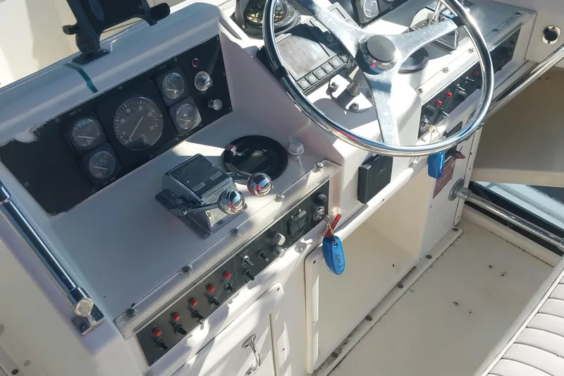 Slide: The Image of Control panel of a 1988 Hatteras 40 Double Cabin yacht, featuring gauges and steering wheel. - 5