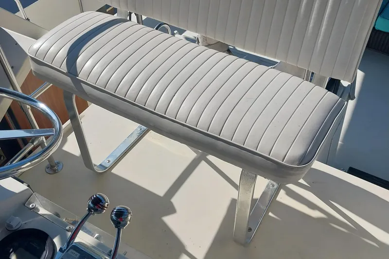 Slide: The Image of Captain's seat on 1988 Hatteras 40 Double Cabin yacht, featuring sleek white upholstery. - 6