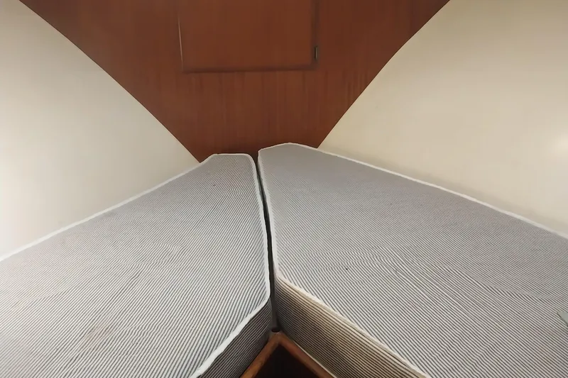 Slide: The Image of 1988 Hatteras 40 Double Cabin interior with twin beds in a cozy cabin setting. - 8