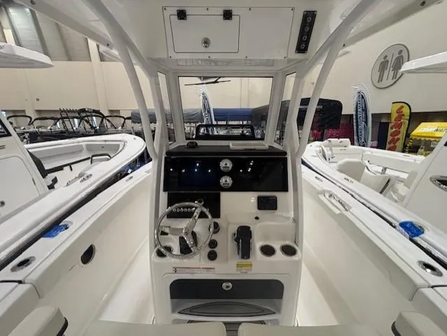 Slide: The Image of 2025 Sea Pro 242 Center Console boat interior with steering wheel and control panel. - 13