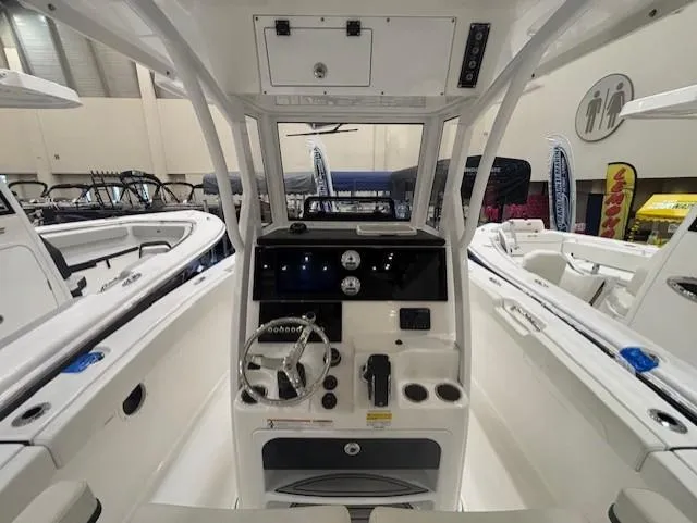 Slide: The Image of 2025 Sea Pro 242 Center Console boat interior with steering wheel and control panel. - 14