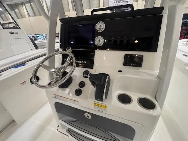 Slide: The Image of 2025 Sea Pro 242 Center Console boat dashboard with steering wheel and controls. - 15