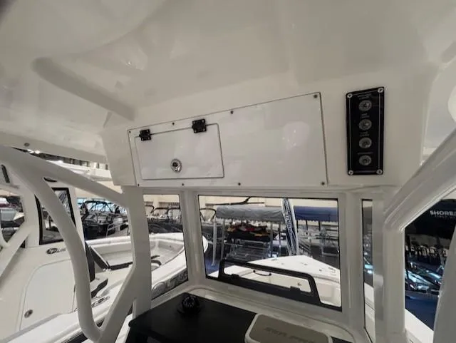 Slide: The Image of 2025 Sea Pro 242 Center Console boat interior with control panel and storage compartment. - 16