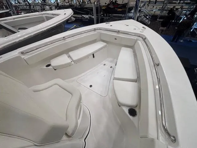 Slide: The Image of 2025 Sea Pro 242 Center Console boat interior with white seating and stainless steel railings. - 19