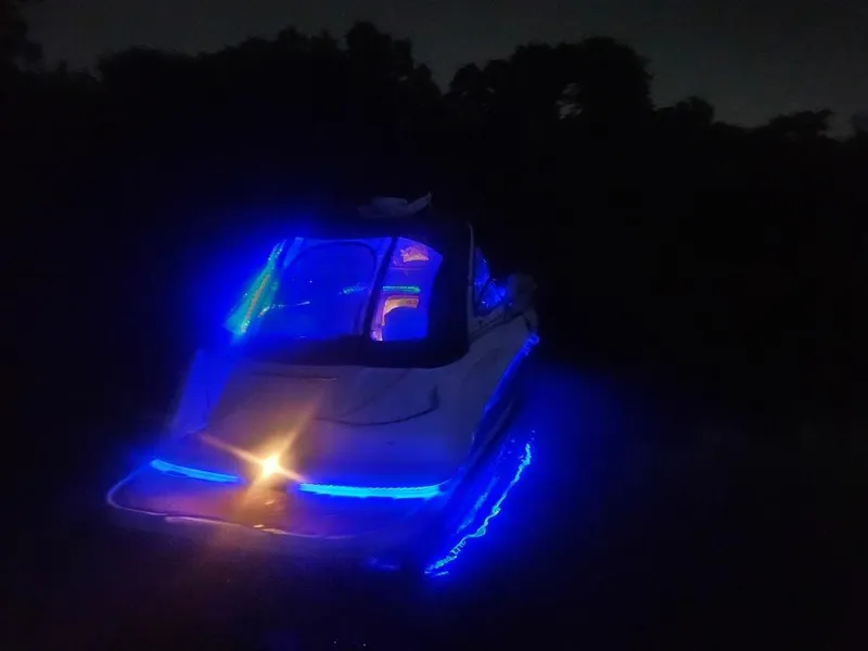 Slide: The Image of 2003 Chaparral Signature 280 boat illuminated with vibrant blue LED lights at night. - 13