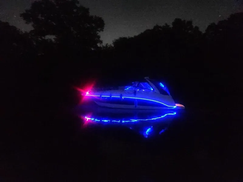 Slide: The Image of 2003 Chaparral Signature 280 boat illuminated with vibrant blue and red lights at night. - 14