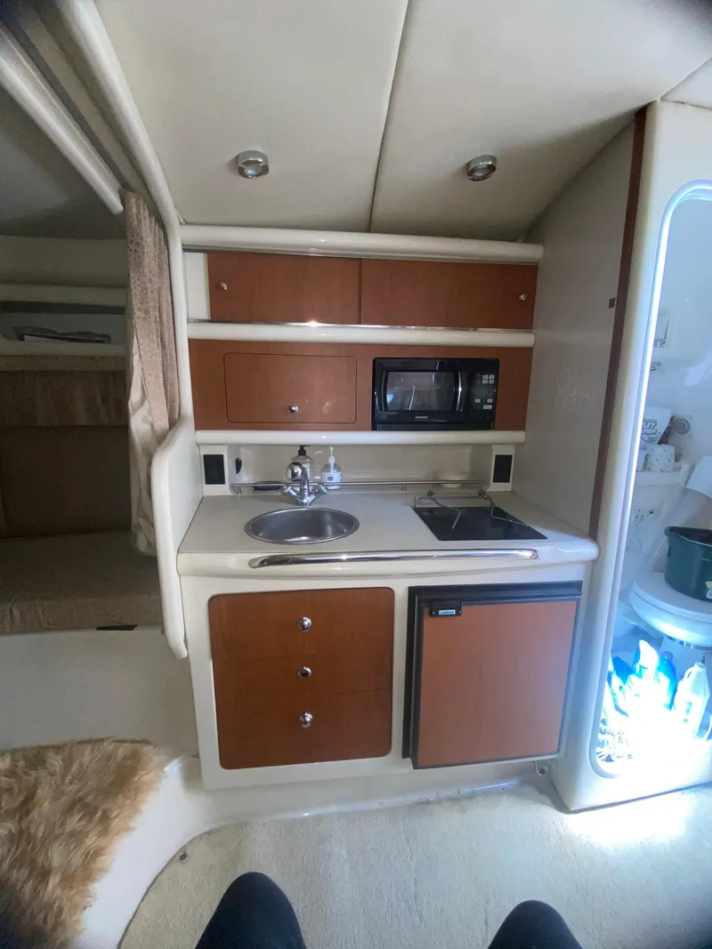 Slide: The Image of 2003 Chaparral Signature 280 cabin kitchen with sink, stove, and microwave. - 21