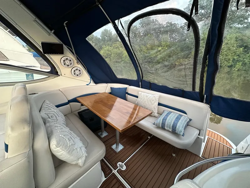 Slide: The Image of 2003 Chaparral Signature 280 interior with cushioned seating, wooden table, and blue canopy. - 25