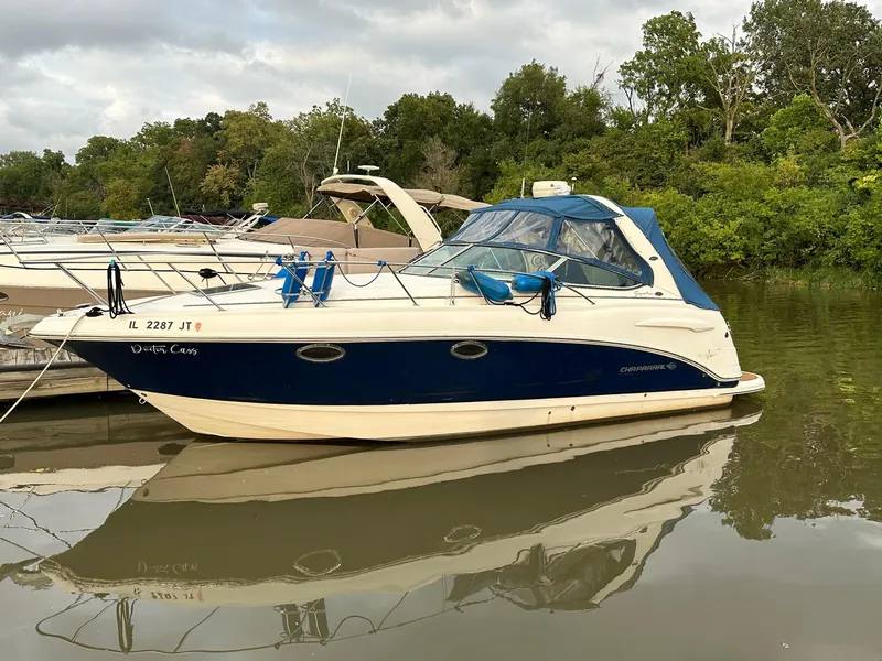 Slide: The Image of 2003 Chaparral Signature 280 boat docked on calm water, surrounded by lush greenery. - 9