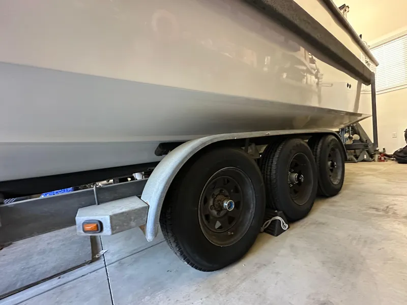 Slide: The Image of Trailer with triple axles supporting a 2005 Farallon 28 boat in a garage. - 17