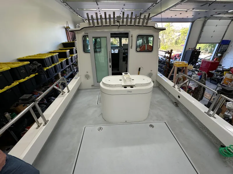 Slide: The Image of 2005 Farallon 28 boat interior in a garage, featuring a central console and storage racks. - 21
