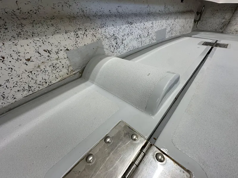 Slide: The Image of Interior detail of a 2005 Farallon 28 boat, featuring textured surfaces and metal hinges. - 22