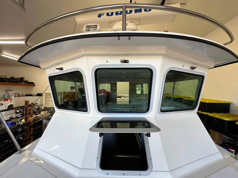 Slide: The Image of 2005 Farallon 28 boat cabin with windows and open hatch in a garage. - 25