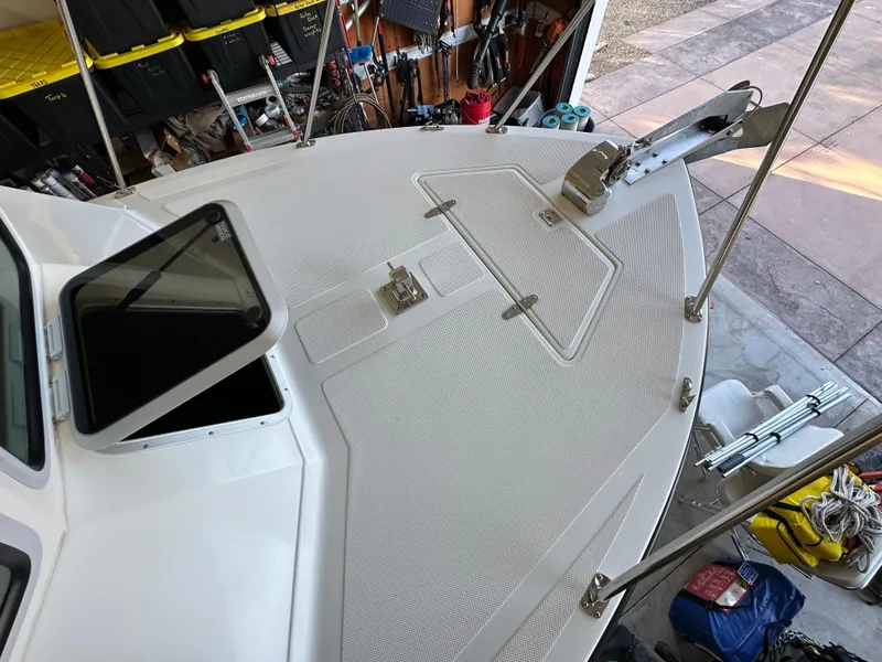 Slide: The Image of 2005 Farallon 28 boat deck with open hatch and anchor, in a garage setting. - 27