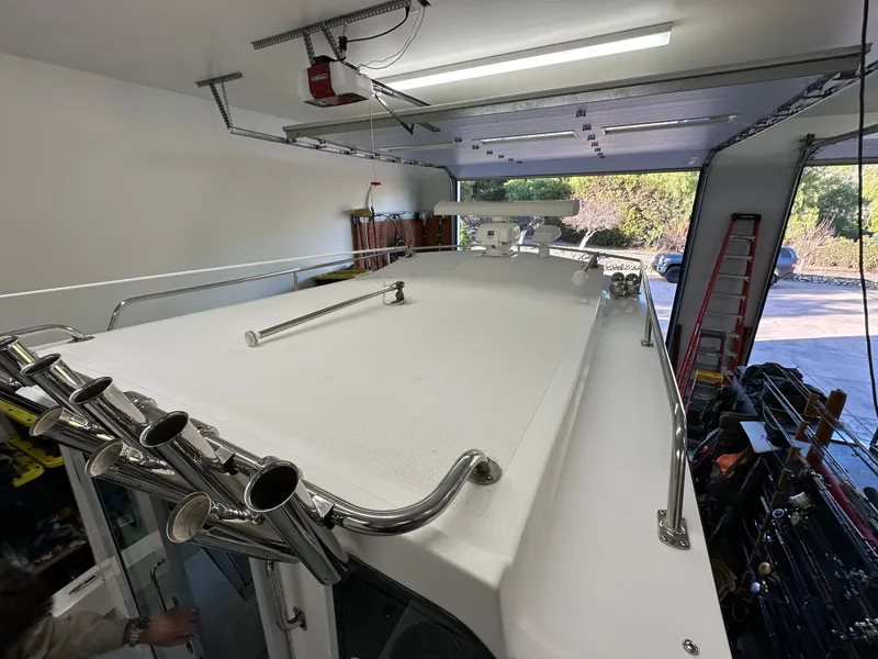 Slide: The Image of 2005 Farallon 28 boat in garage, showing roof and rod holders. - 28