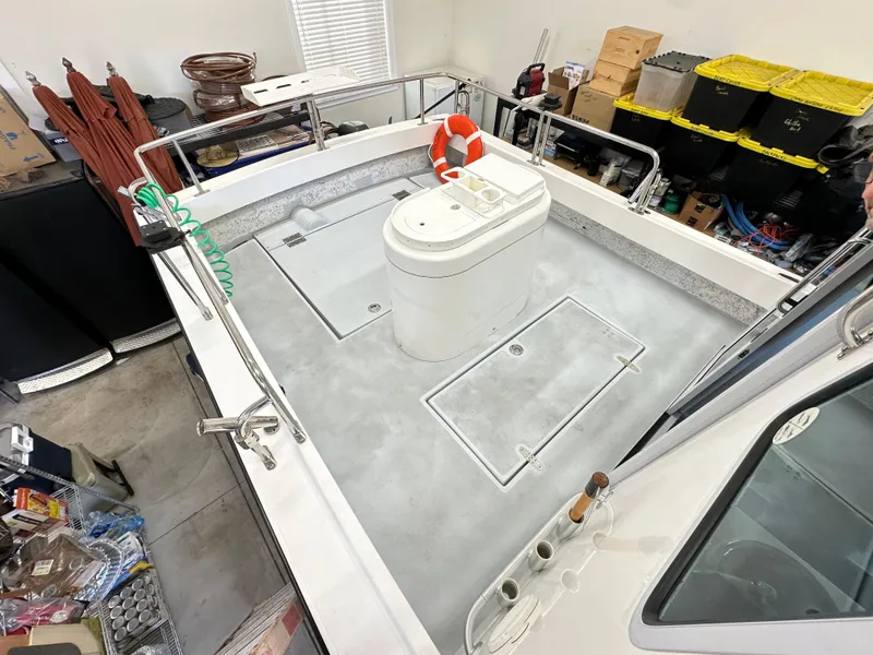 Slide: The Image of Farallon 28 boat deck, 2005 model, with storage hatches and safety equipment in a garage setting. - 29