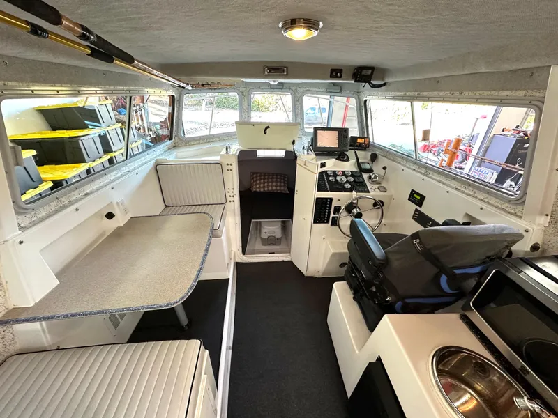 Slide: The Image of Interior of a 2005 Farallon 28 boat with seating, navigation equipment, and kitchenette. - 32