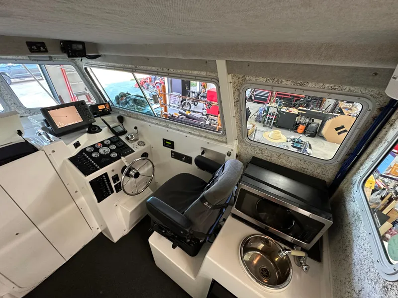 Slide: The Image of 2005 Farallon 28 boat interior with steering console, navigation equipment, and kitchenette. - 36