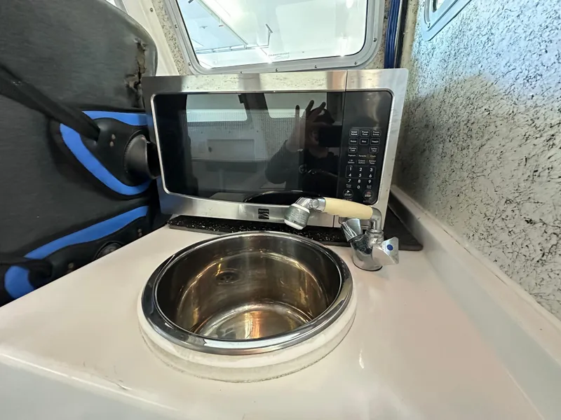 Slide: The Image of Compact kitchen area in a 2005 Farallon 28 boat with microwave and sink. - 39