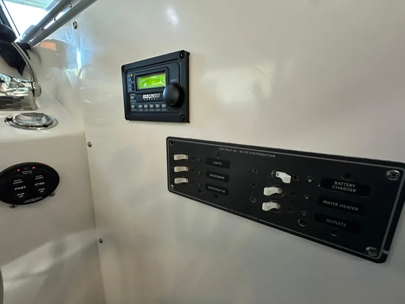 Slide: The Image of Control panel of a 2005 Farallon 28 boat, featuring switches and a display. - 48