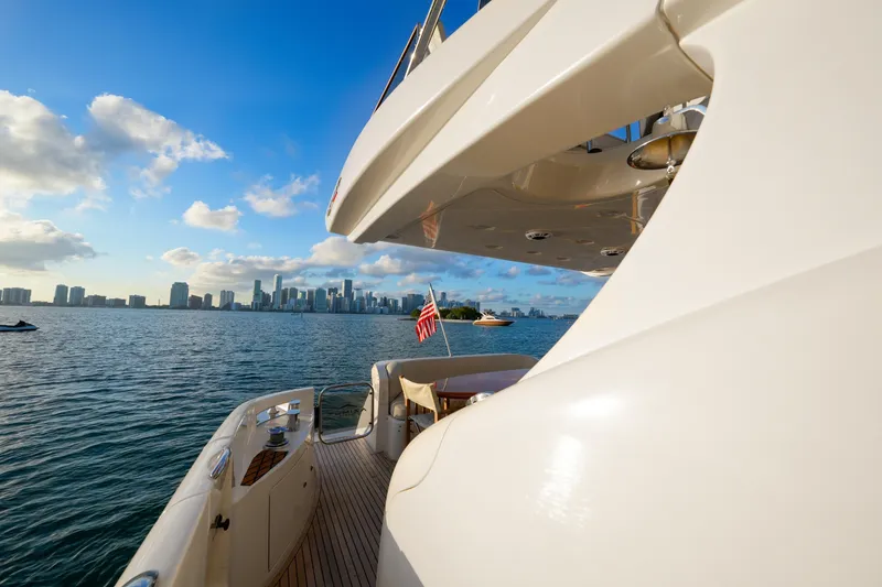 Slide: The Image of Azimut 68E yacht cruising near city skyline, 2007 model, sunny day, American flag visible. - 16