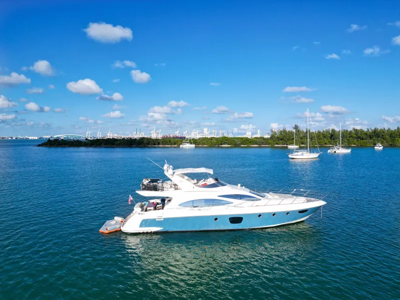 Slide: The Image of 2007 Azimut 68E yacht on calm blue water under a clear sky. - 2