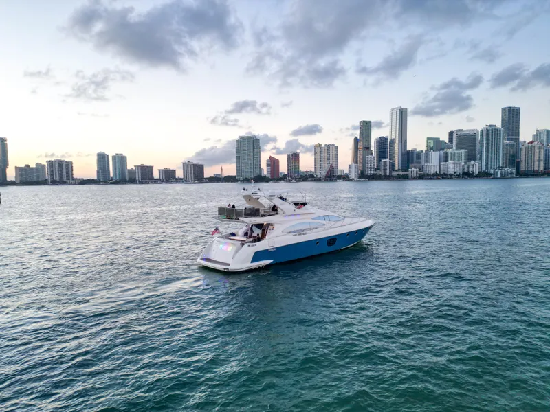 Slide: The Image of 2007 Azimut 68E yacht cruising near a city skyline at sunset. - 4