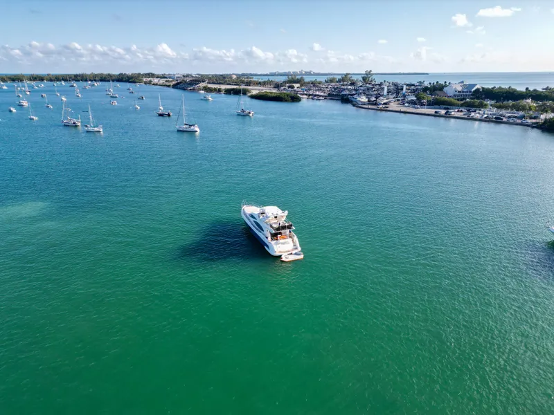Slide: The Image of Azimut 68E 2007 yacht on serene turquoise waters with distant shoreline and boats. - 8