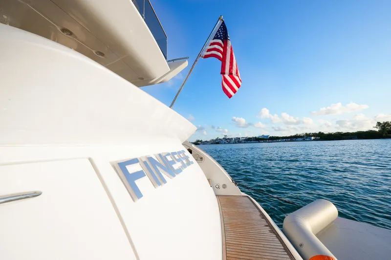 Slide: The Image of 2007 Azimut 68E yacht with American flag, docked on calm waters under blue sky. - 9