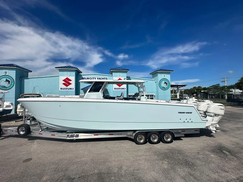 The Image of 2025 Twin Vee 400 GFX2 CC boat on trailer at Palm City Yachts dealership. - 1