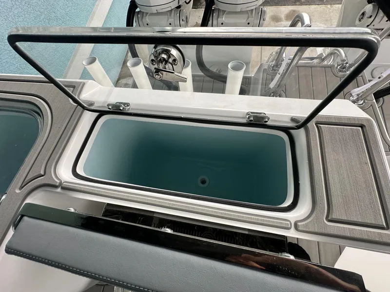 Slide: The Image of 2025 Twin Vee 400 GFX2 CC boat storage compartment with open lid, showcasing interior design. - 13