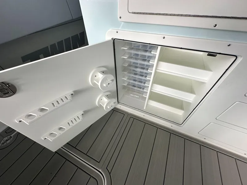 Slide: The Image of Open storage compartment on 2025 Twin Vee 400 GFX2 CC boat, featuring organized shelves. - 22