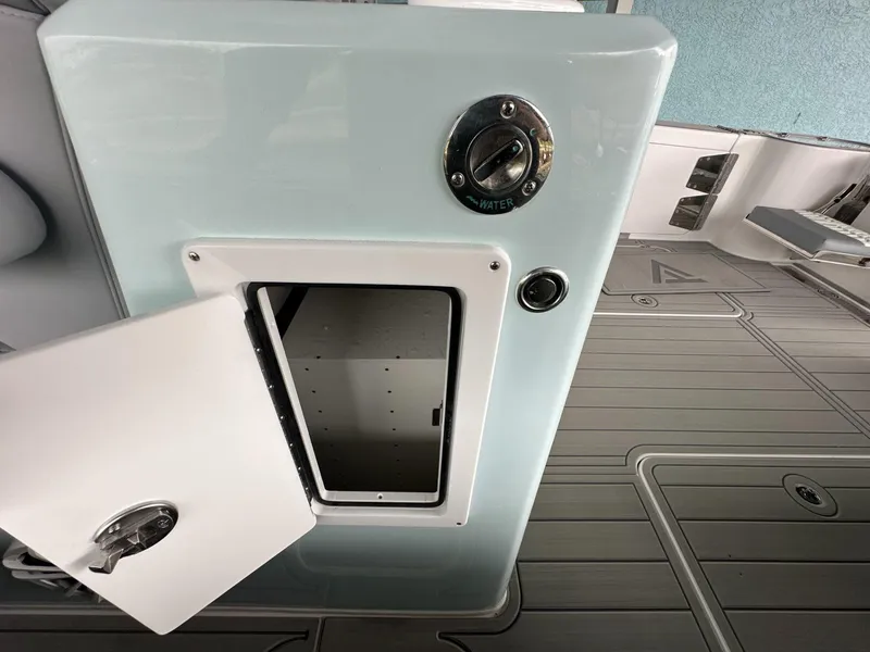 Slide: The Image of 2025 Twin Vee 400 GFX2 CC boat storage compartment with open hatch and water access. - 24