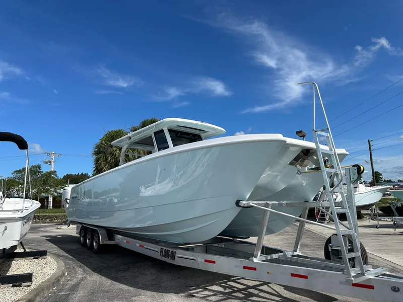 Slide: The Image of 2025 Twin Vee 400 GFX2 CC boat on trailer under clear blue sky. - 3