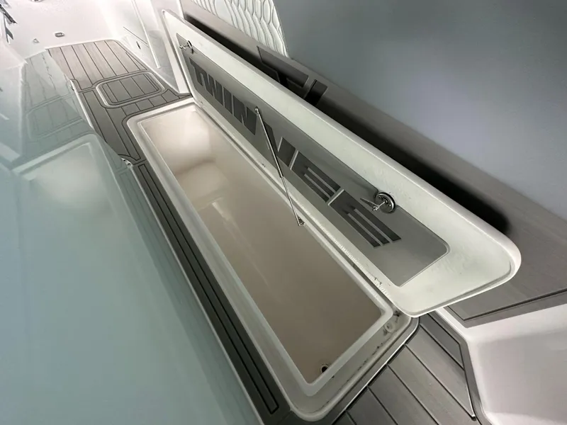 Slide: The Image of 2025 Twin Vee 400 GFX2 CC boat storage compartment, open lid, sleek design. - 32