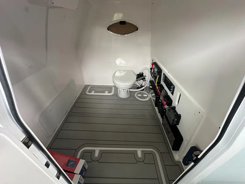 Slide: The Image of Interior of 2025 Twin Vee 400 GFX2 CC boat, featuring a compact marine toilet. - 39