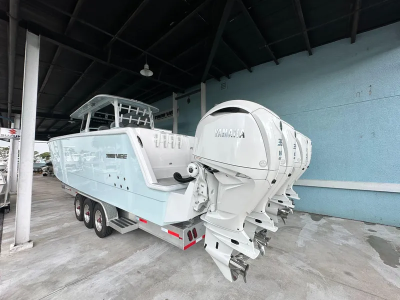 Slide: The Image of 2025 Twin Vee 400 GFX2 CC boat with triple Yamaha outboard engines on a trailer. - 5