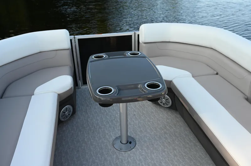 Slide: The Image of 2025 Princecraft Vectra 23 RL boat interior with seating and table, on calm water. - 4