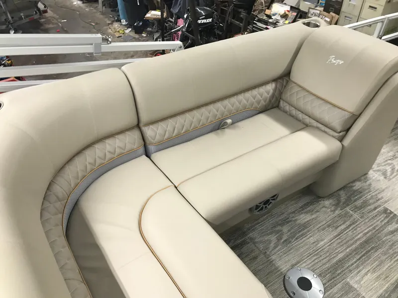 Slide: The Image of 2025 Ranger Reata 223FC boat interior with beige seating and black console. - 13