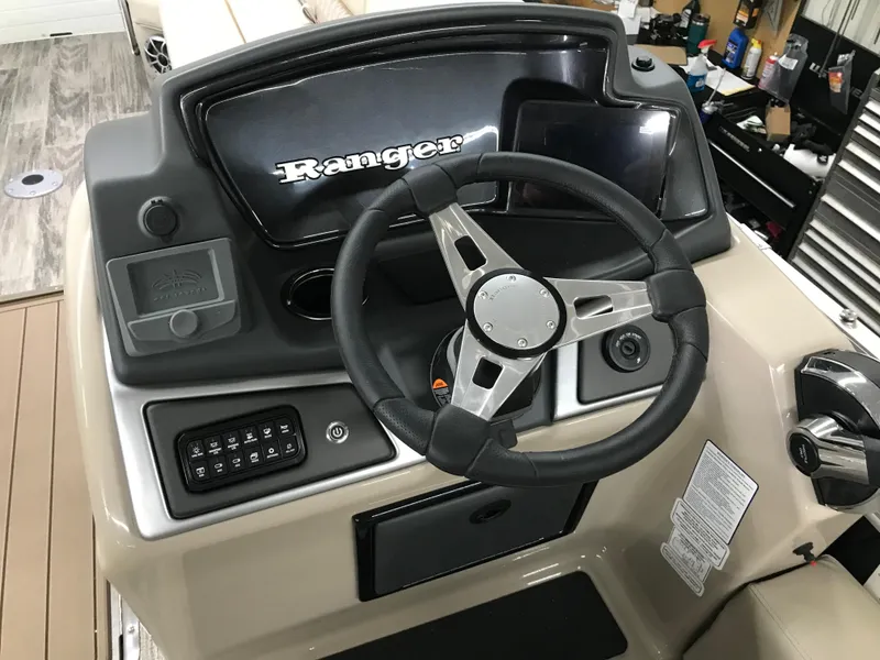 Slide: The Image of 2025 Ranger Reata 223FC boat interior with storage compartment and aluminum railing. - 17