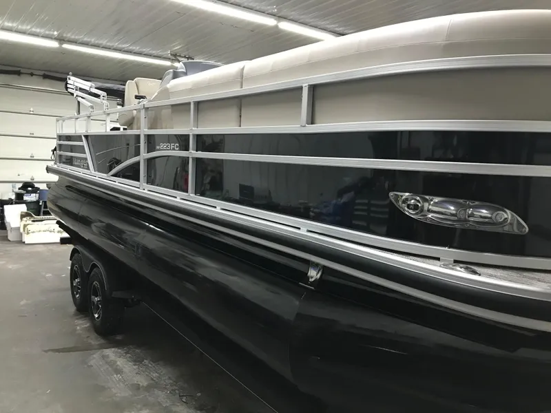 Slide: The Image of 2025 Ranger Reata 223FC boat in a garage, showcasing its sleek design and sturdy build. - 5