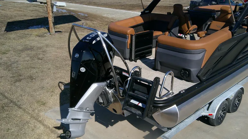 Slide: The Image of 2025 Bennington MFB 26 boat with outboard motor and luxurious seating on a trailer. - 10